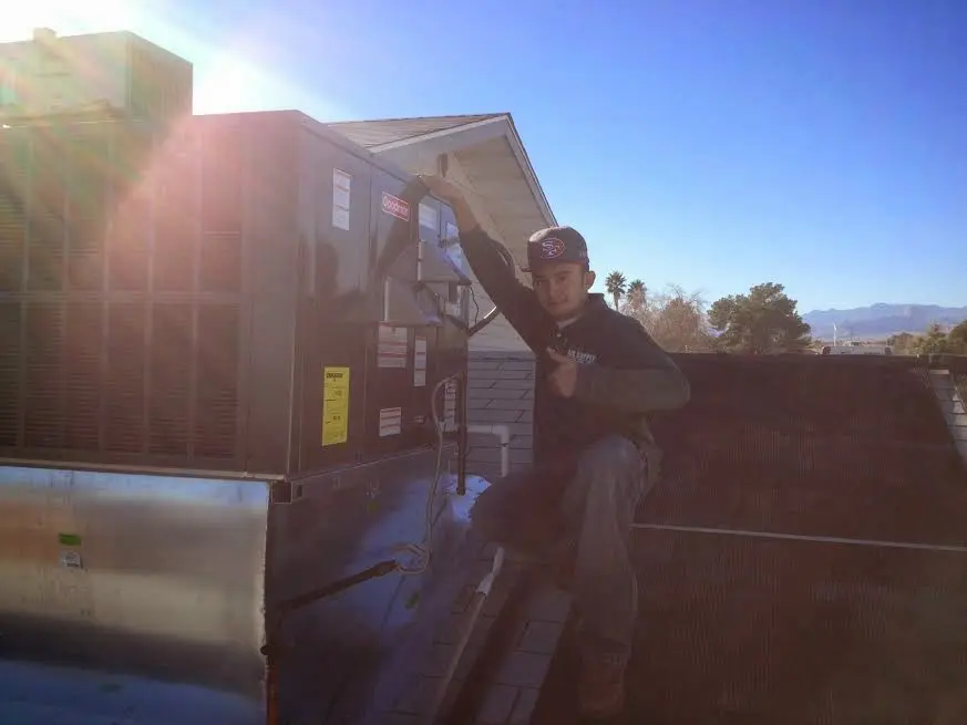 HVAC technician performing Air Duct Cleaning on a rooftop unit in Pelham